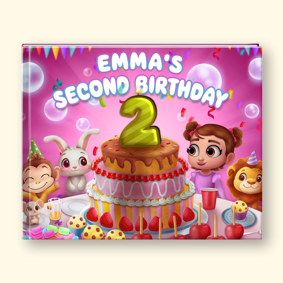 A square hardcover notebook or journal cover featuring a colorful cartoon birthday illustration with the text 'EMMA'S SECOND BIRTHDAY' and a large gold number 2 candle on a pink party background.